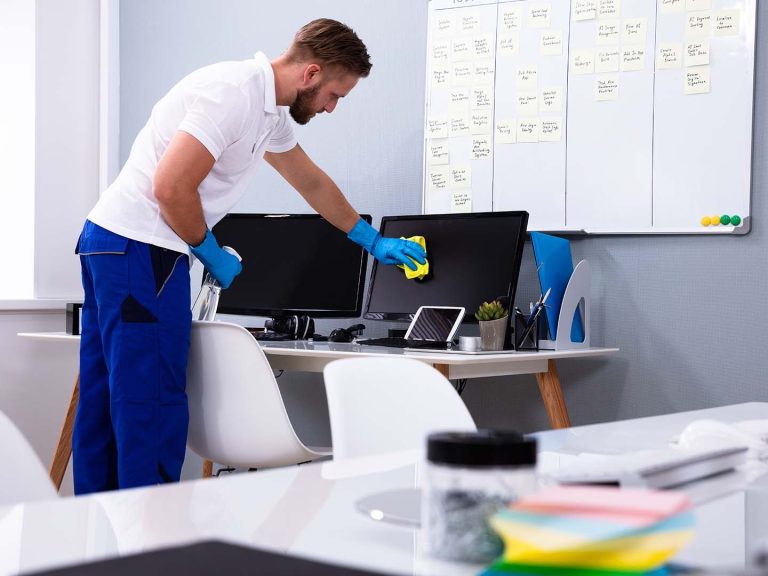 Profesional de limpieza desinfectando oficina para garantizar un ambiente higiénico y productivo